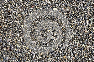 Top view of grey small wet pebble stones at sea beach