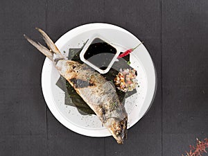 Top view of Grilled Boneless Bangus stuffed with vegetables and served with soysauce and Atchara. Bangus is also known as Milkfish