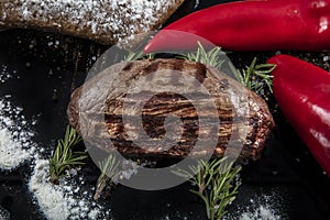 Top view of grilled filet mignon beef steaks on a black wooden surface