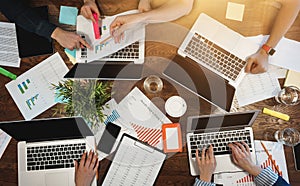 Top view of group business people sitting at table and using modern laptop, graphs and diagrams. Team of architecture are having a