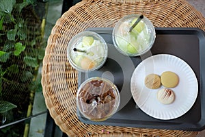 Top view a group of cool softdrink with latte coffee and sweet macarons in a tray