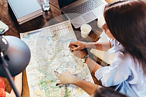 Top view of group of girls with map sitting at desk