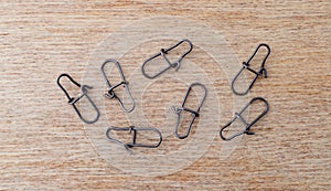 Top view of a group of lock snaps used for fishing leaders on a wood background photo