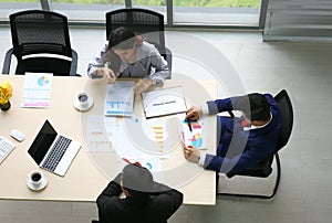 Top view of group of multiethnic busy people working in an office, Aerial view with businessman and businesswoman sitting around a