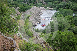 Group of people with guide whitewater rafting and rowing on river, extreme and fun sport at tourist attraction