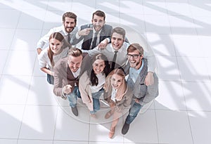 Top view. a group of smiling young business people pointing at you.