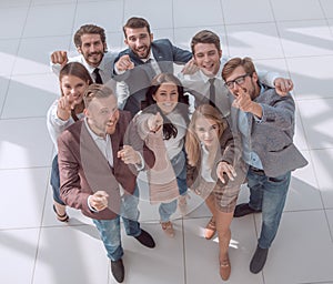 Top view. a group of smiling young business people pointing at you.