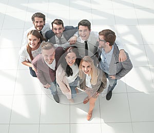 top view. a group of smiling young business people pointing at you.