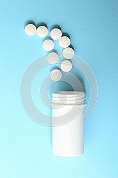 Top view of a group of tablets and plastic bottle on blue