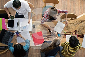 Top view group of teenage friends to be busy working in team with reports and laptop at University