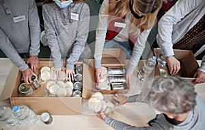 Top view of group of volunteers in community donation center, food bank and coronavirus concept.