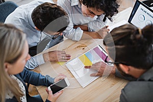 A top view of group of young businesspeople working together in a modern office.