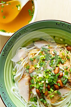 guilin rice noodles with bowl of soup nearby vertical composition