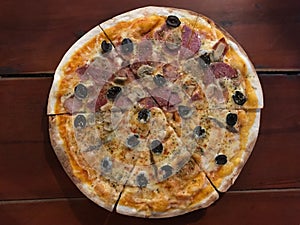 Half of Cubana and Neapolitan pizza on dark brown wooden table photo