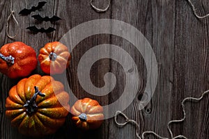 Top view Halloween concept Pumpkin decorations and black paper bat flying over the wooden floor.