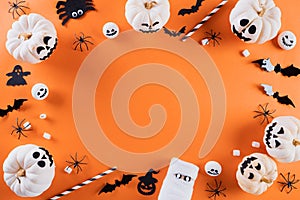 Top view of Halloween crafts, orange pumpkin, ghost, bat and spider on orange background with copy space for text. halloween