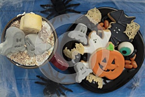 Top view of Halloween snack with spooky beverage, cookies and treats