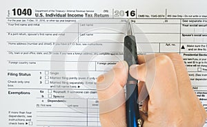 Top view of hand hold pen fill in the details on the tax forms paper in business concept.