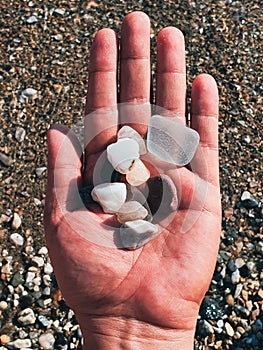 top view of a hand holding colorful pebbles at beach - Bodrum, Turkey