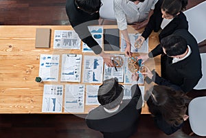 Top view hand holding gear by group of businesspeople on table in harmony office