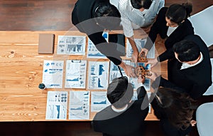 Top view hand holding gear by group of businesspeople on table in harmony office