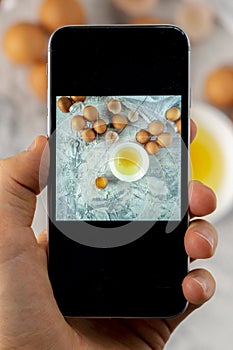 top view of hand holding a phone doing a mobiles food photography