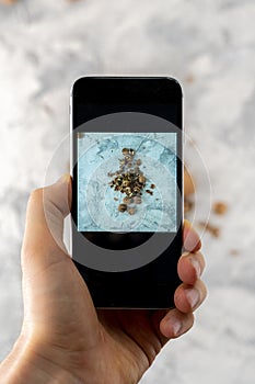 top view of hand holding a phone doing a mobiles food photography