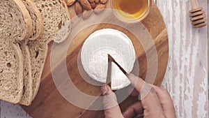 top view of hand pick a slice of cheese from a chopping board