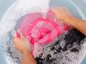 Top view of soaking colored clothes in laundry detergent water photo