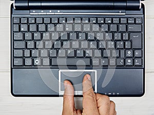 Top view hand using touchpad laptop keyboard