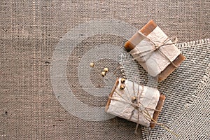 Top view on handmade natural soap bars or dry shampoo with flax flower on rustic fabric. Close up of home spa products made with