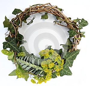 Top view of handmade rustic wreath with ivy leaves on white background. Creative composition. Seasons greetings card