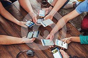 Top view hands circle using phone in cafe - Multiracial friends mobile addicted interior scene from above - Wifi connected people