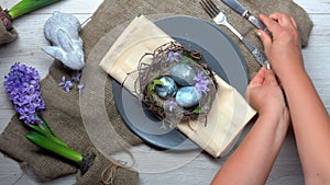 Top view of hands placing plate with Easter eggs on table