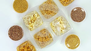 Top view, hands, in protective gloves, nicely arrange, put the packagings, boxes of pasta, cereals. rotation on white