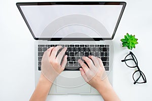 Top view, The hands of women use a laptop computer with a white screen on a modern desk. Flat lay