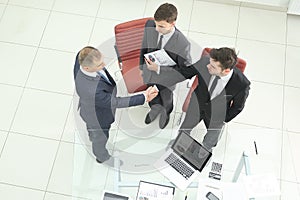 Top view.handshake of financial partners before the business meeting