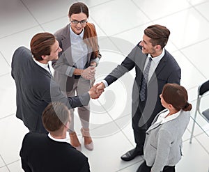 Top view.handshake trading partners in the office