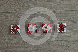 Top view of hanging small Christmas gift boxes on a wooden table with copy space