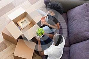 Top view happy African American couple in love unpack boxes at home