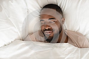 Calm biracial man sleeping seeing pleasant dreams