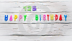 Top view of happy birthday 125 candle numbers copy space on wooden white pastel boards. Beautiful birthday card with number