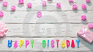Top view of happy birthday 8 candle letters for a girl in pink shades with beautiful rose flowers, postcard congratulation copy