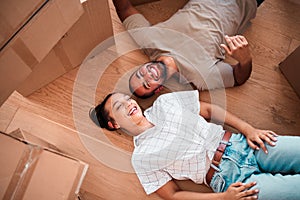 Top view, happy couple and moving into new home on floor, ground and relax from packing boxes. Man, woman and taking a