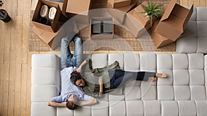 Top view happy couple relaxing on couch after relocation