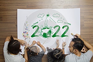Top view happy family lying on floor, With creative painting 2022 New year earth eco environmental