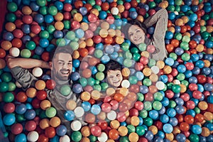 Top view. Happy family lying in pool with balls