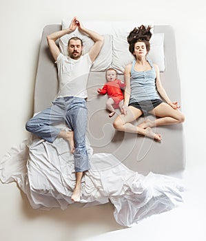 Top view of happy family with one newborn child in bedroom.