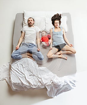 Top view of happy family with one newborn child in bedroom.