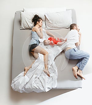 Top view of happy family with one newborn child in bedroom.